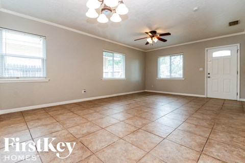 A spacious room with a ceiling fan and tile flooring.