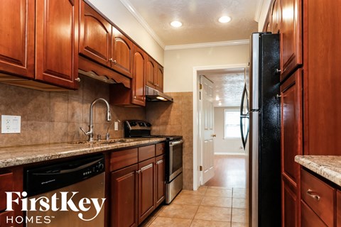 A kitchen with wooden cabinets and a black refrigerator.