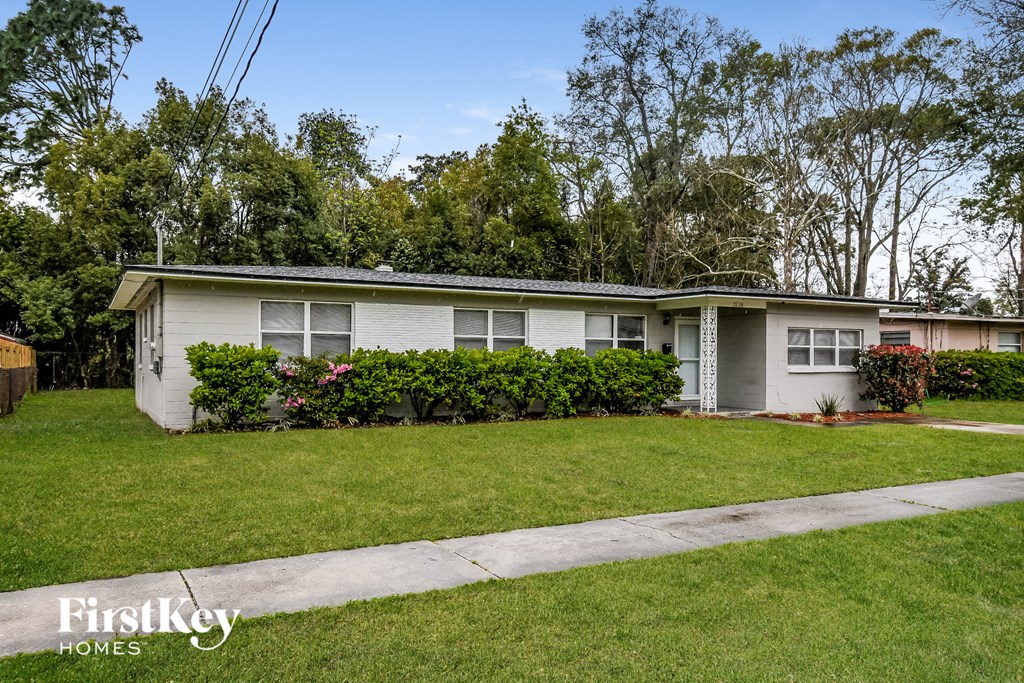 a white house with a lawn and a sidewalk