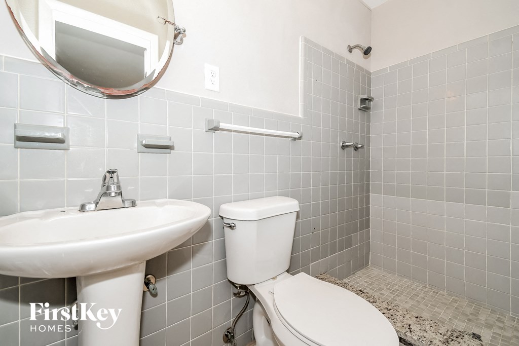 a bathroom with a toilet and a sink and a mirror