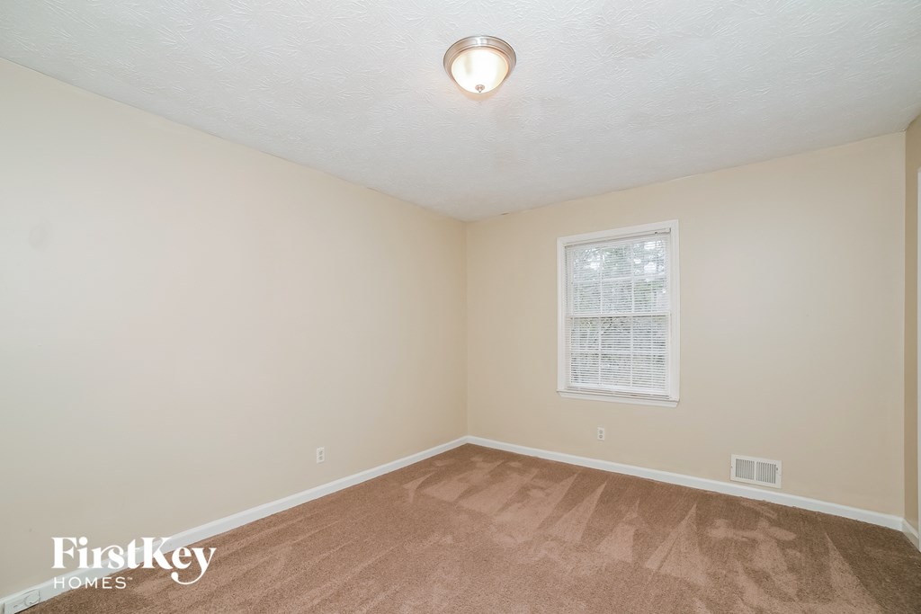 a bedroom with a carpeted floor and a window