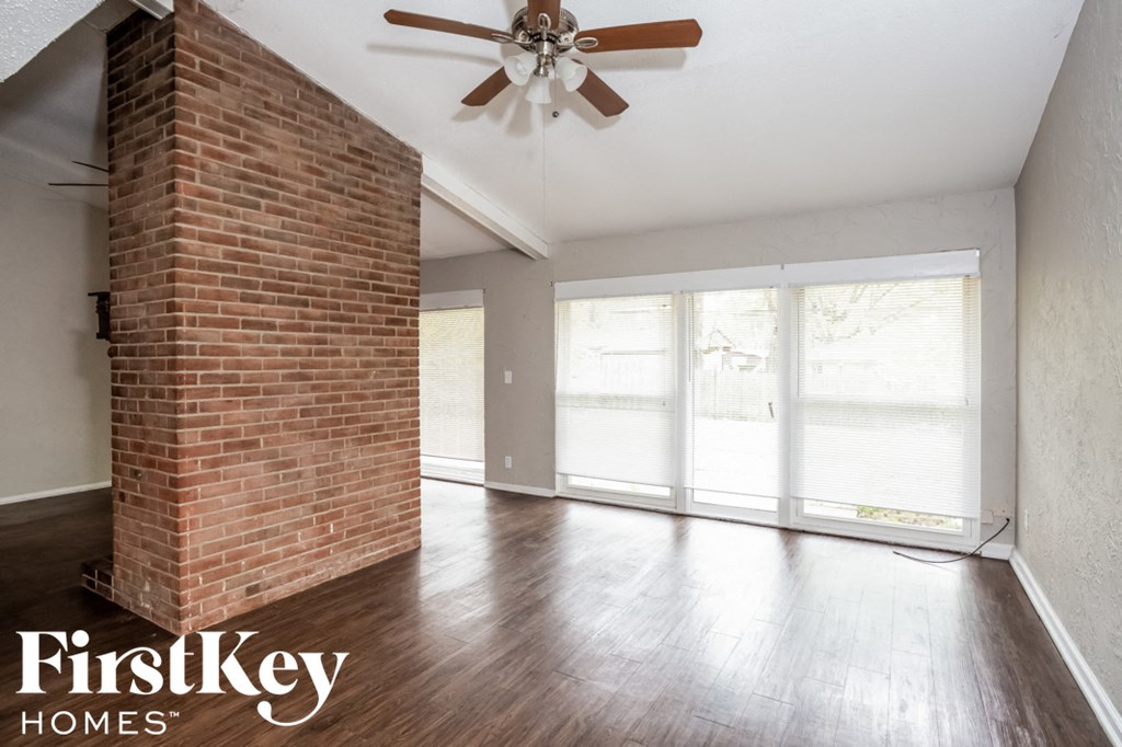 A room with a brick pillar and a ceiling fan.