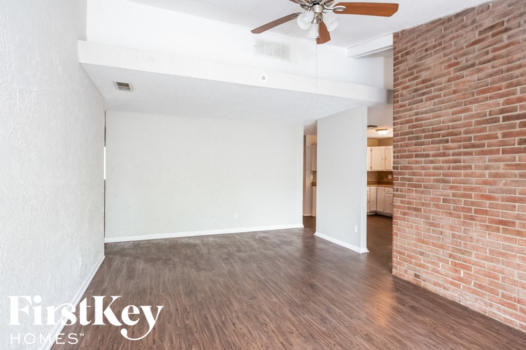 A room with a brick wall and wooden flooring.