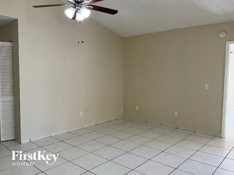 A room with a ceiling fan and tiled floor.