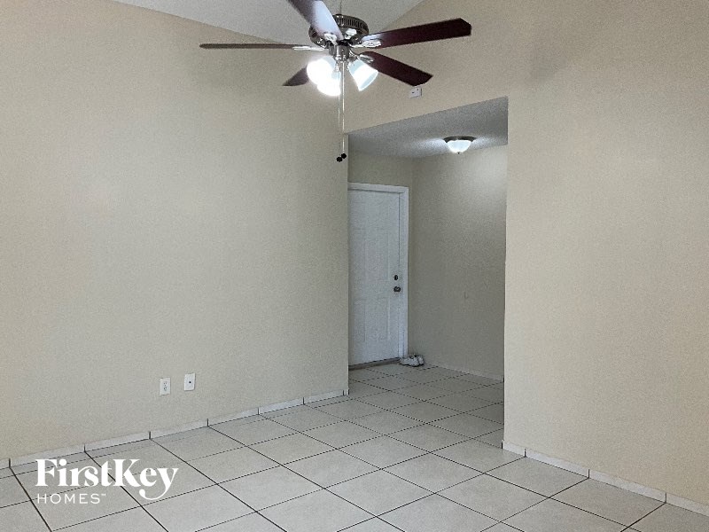 A room with a ceiling fan and a door.