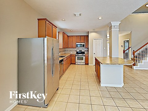 a large kitchen with stainless steel appliances and wooden cabinets