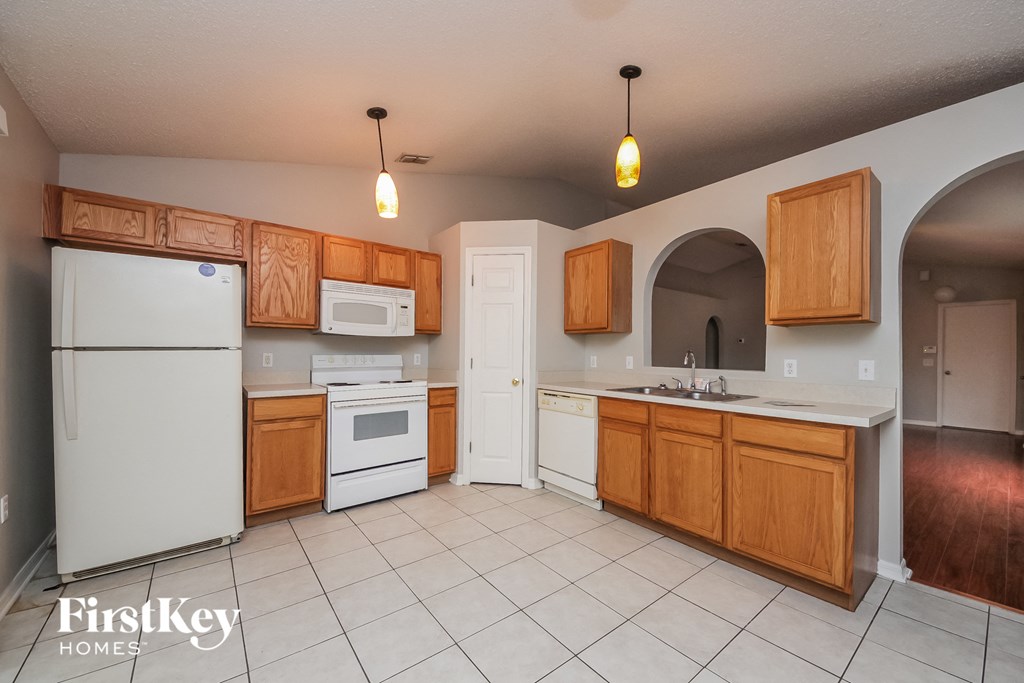 A kitchen with wooden cabinets and a white refrigerator.