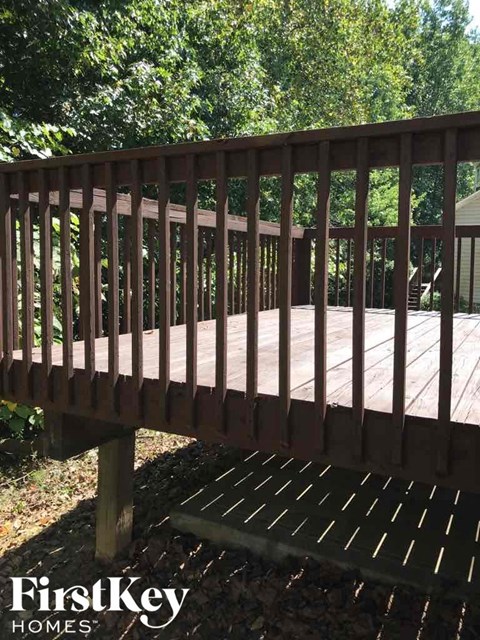 A wooden deck with a railing and a FirstKey Homes logo.