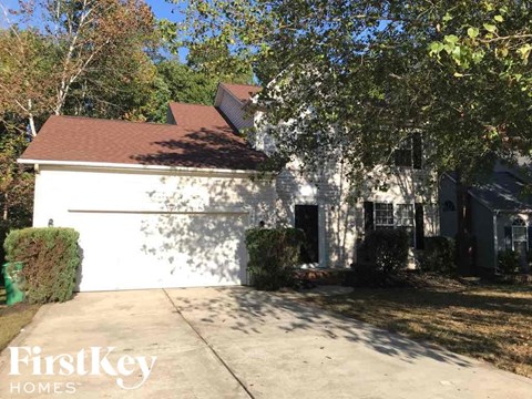 A house with a white exterior and a brown roof is shown with the logo "FirstKey Homes" in the bottom left corner.