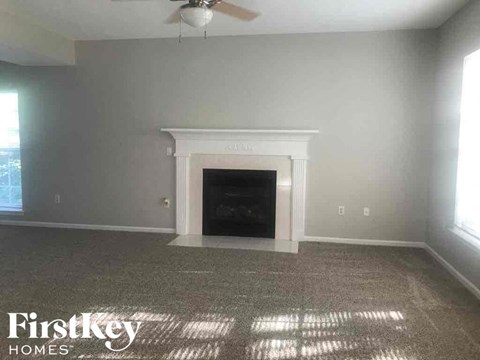 A room with a fireplace and a fan on the ceiling.