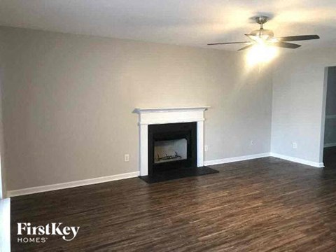 a living room with a fireplace and a ceiling fan