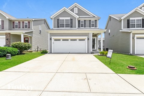 a gray house with a white garage door on a driveway