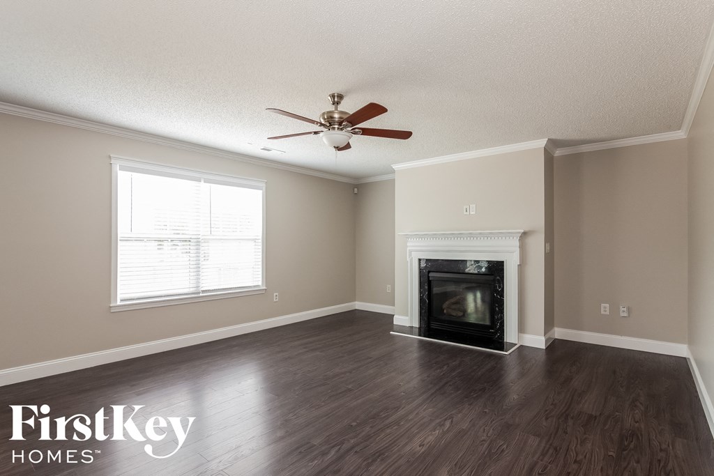 a living room with a fireplace and a ceiling fan