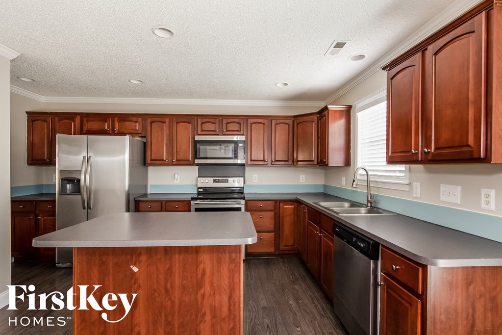 a kitchen with wooden cabinets and stainless steel appliances
