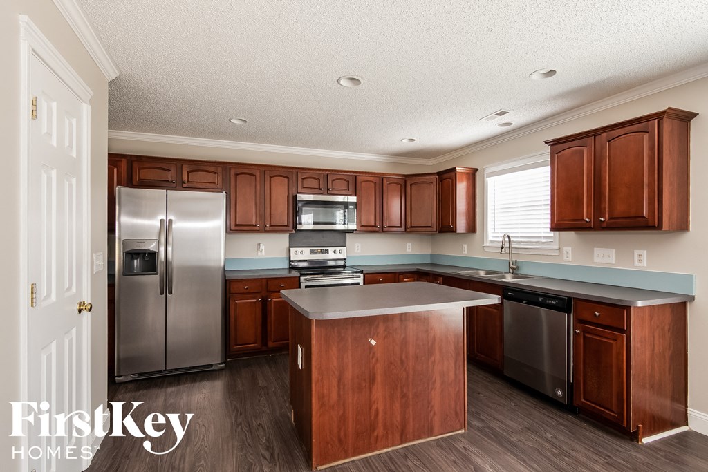 a kitchen with wooden cabinets and stainless steel appliances