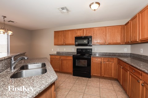 A kitchen with wooden cabinets and a black oven.