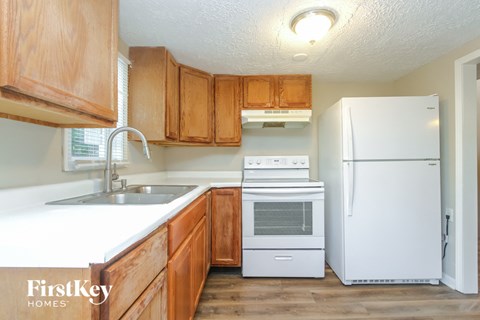 A kitchen with wooden cabinets and a white fridge.