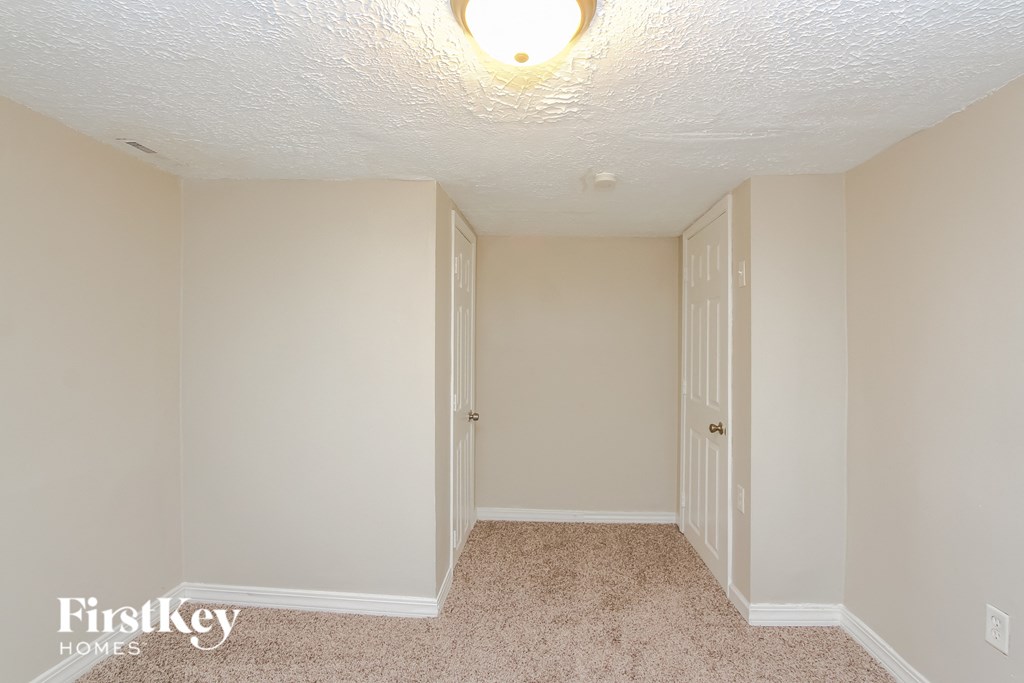 A carpeted hallway with a door on the right.