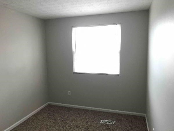 an empty room with a window and a carpet