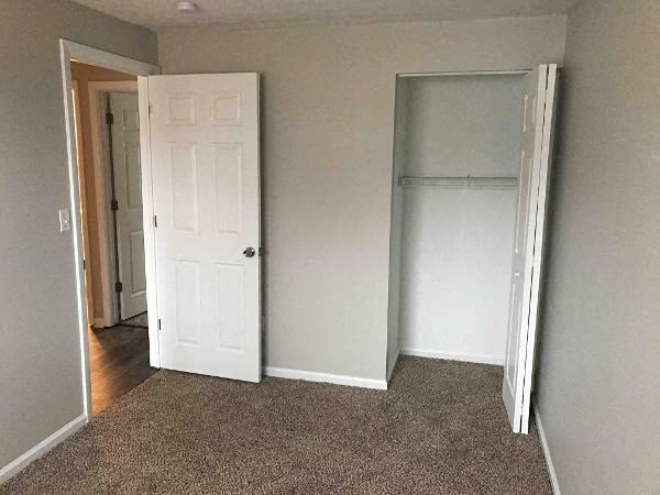 an empty room with a white door and a closet