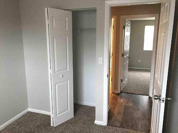 an empty room with a door open and a hallway