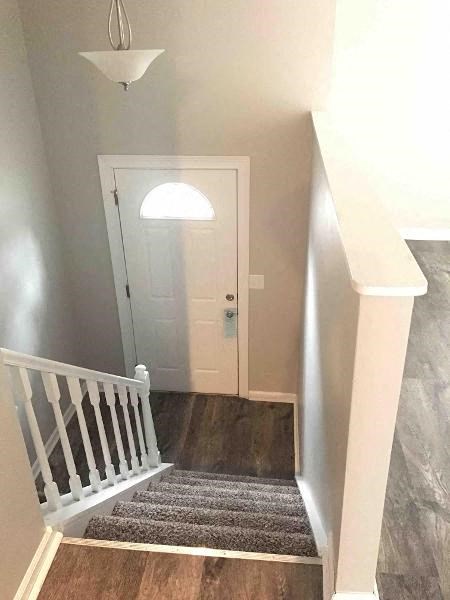 a hallway with a staircase and a white door