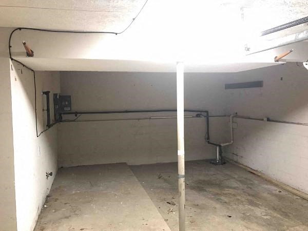a basement with a sink and pipes in it