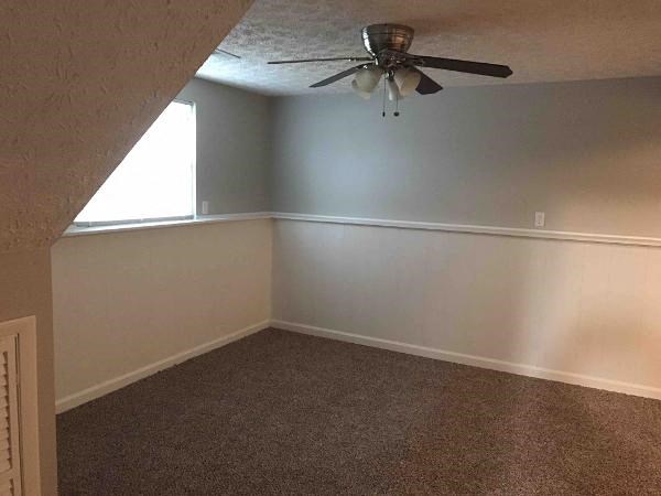 an empty room with a ceiling fan in it