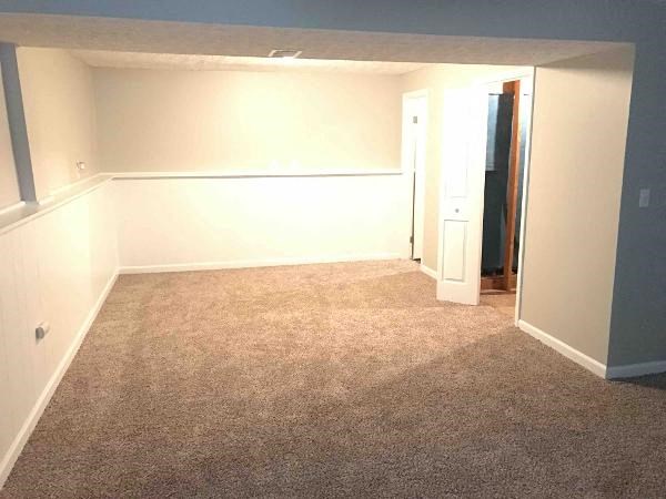an empty room with a carpeted floor and white walls