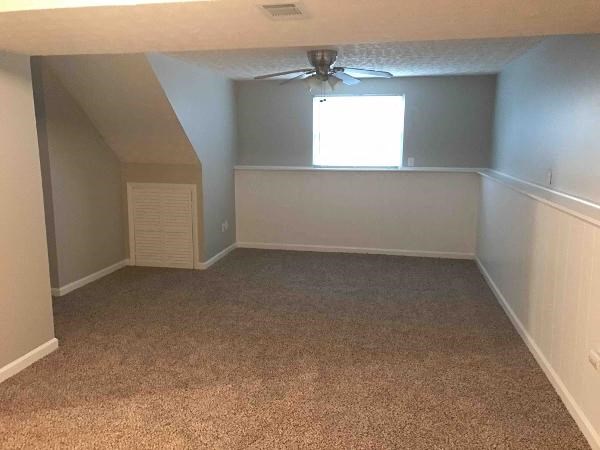an empty room with a ceiling fan and a window