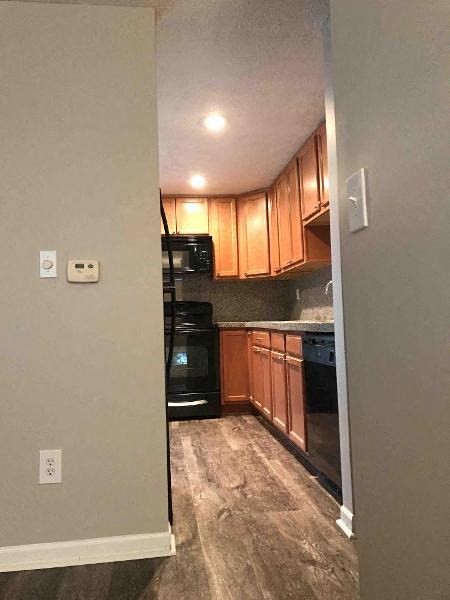 a kitchen with wooden cabinets and black appliances
