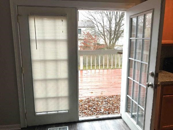 a door is open to a backyard with a deck