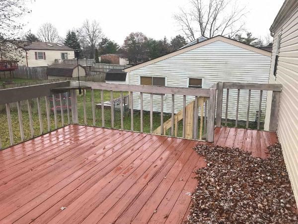 a wooden deck with a fence in a backyard
