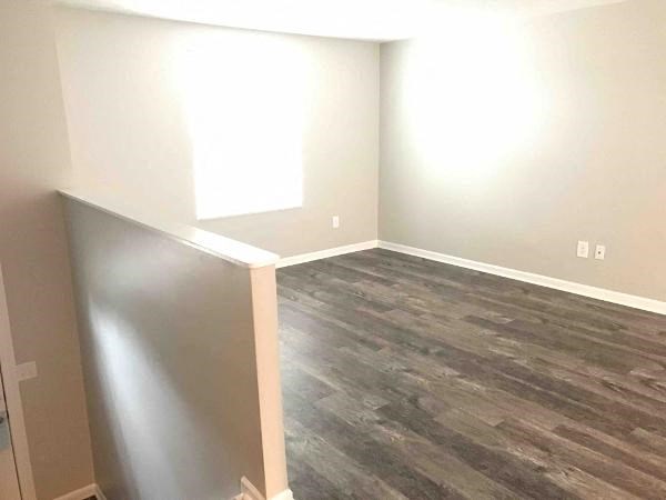 an empty room with wood flooring and white walls