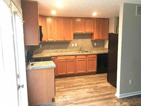 a kitchen with wooden cabinets and a black refrigerator