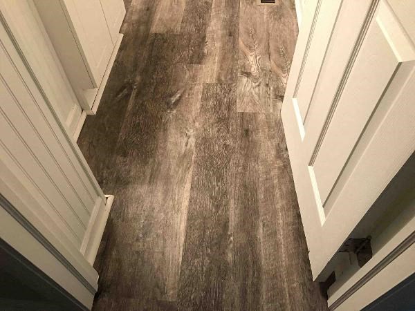 a hallway with wood floors and a white door