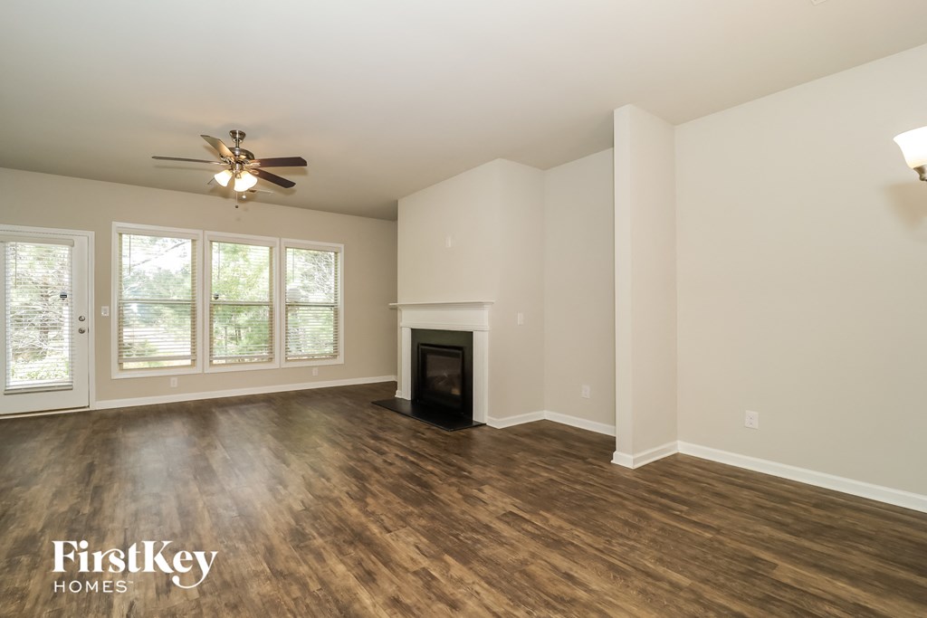 a living room with a fireplace and a ceiling fan