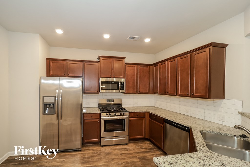a kitchen with wooden cabinets and stainless steel appliances