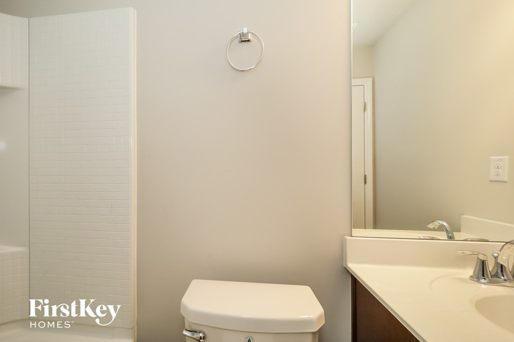 a bathroom with a toilet and a sink and a mirror