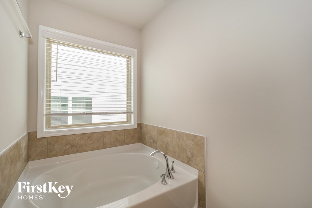a bathroom with a large bath tub and a window