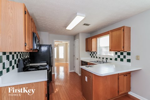 A kitchen with wooden cabinets and a black stove top oven.
