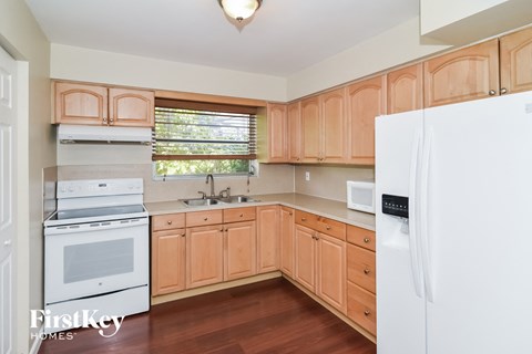 a kitchen with wooden cabinets and a white stove and refrigerator