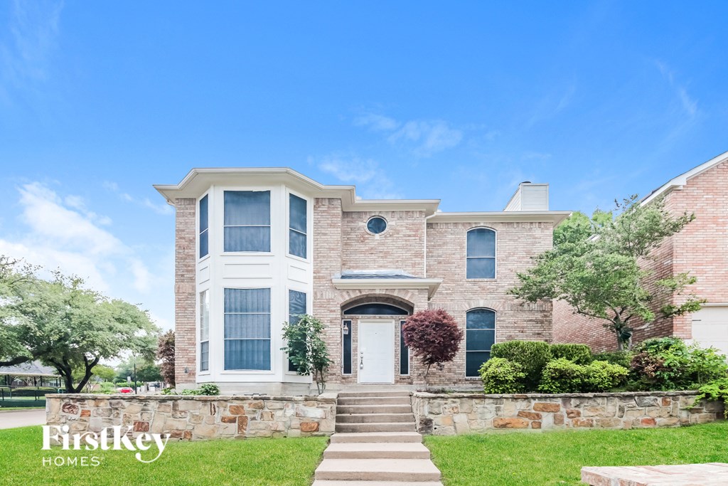 A large house with a stone wall and a white door.