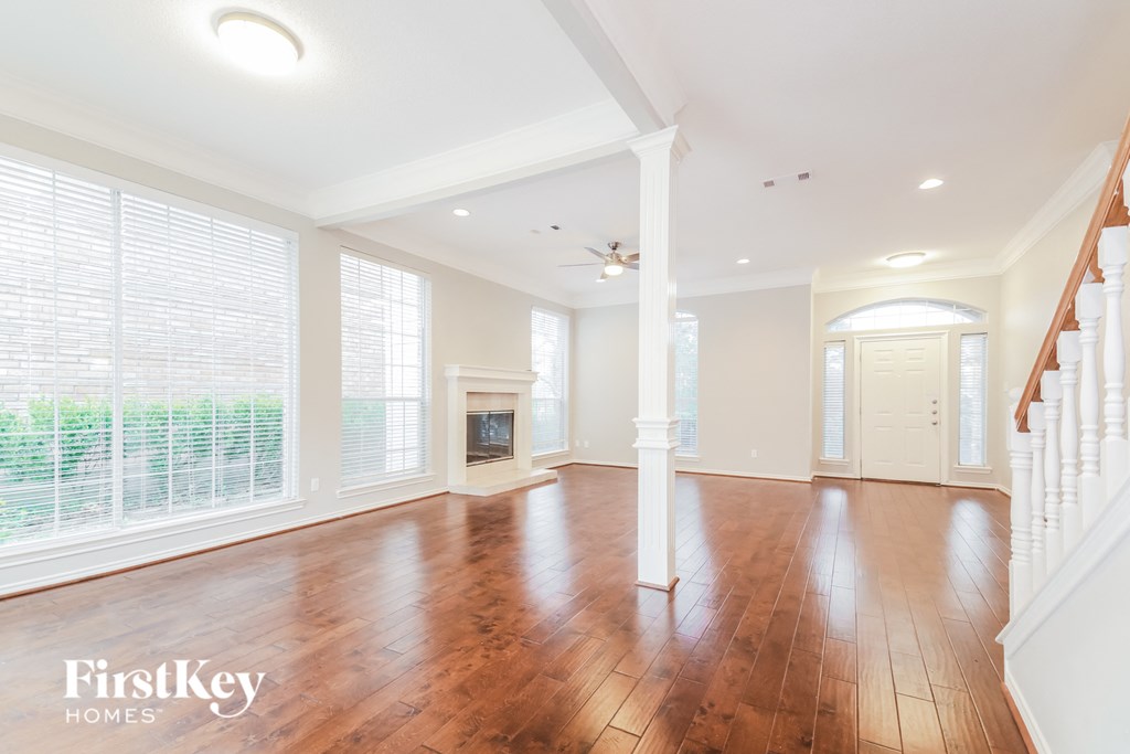A spacious room with wooden floors and white walls.