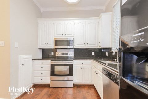 A kitchen with white cabinets and stainless steel appliances.