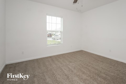 a bedroom with a carpeted floor and a window