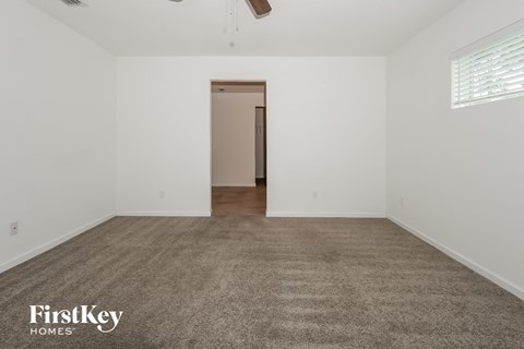 the spacious living room with carpet and white walls
