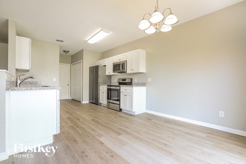 A kitchen with a white counter top and a white fridge.