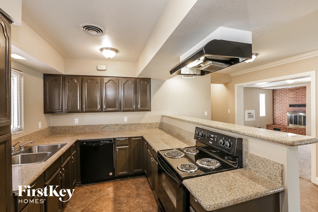 a kitchen with a stove top oven and a sink