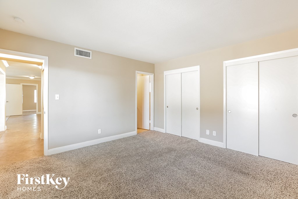 a spacious living room with carpet and white doors